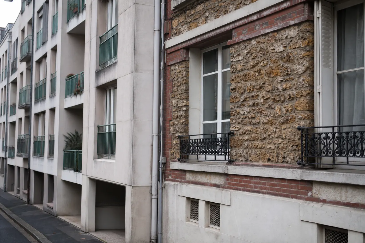 Rue où un immeuble en brique et meulière de l’entre-deux-guerres jouxte un immeuble en béton des années 1960